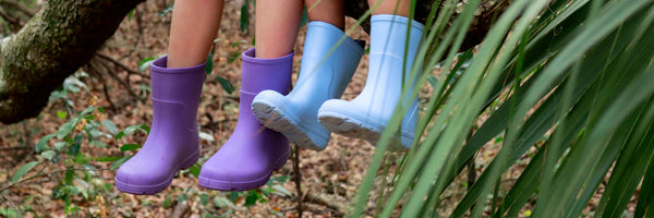 Kids Cirrus Charley Rain Boots in Bonnie Blue and Paisley Purple on figure sitting on a branch in the woods