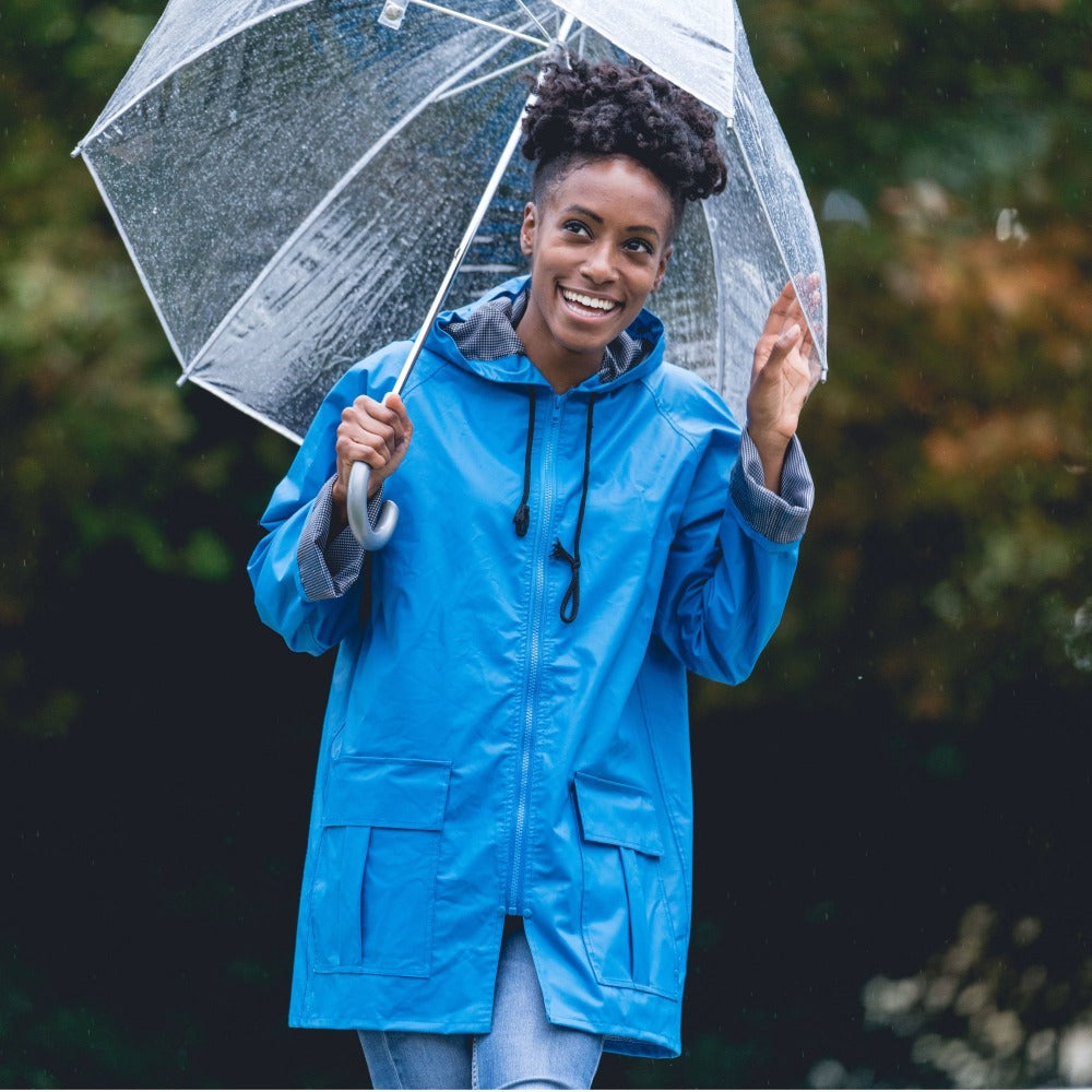 Woman wearing the Lined Rain Slicker in marine outside holding a bubble