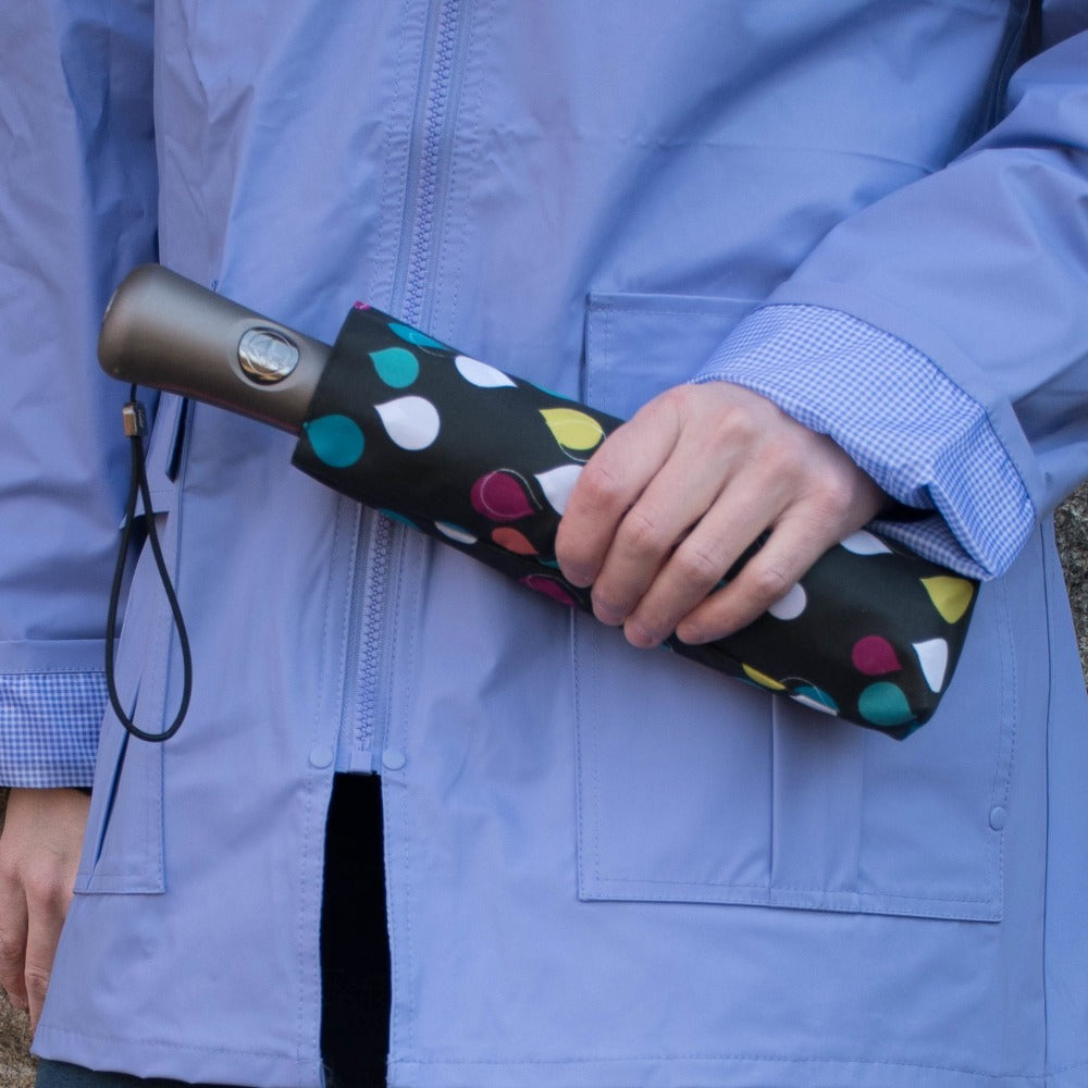 Woman wearing Lined Rain Slicker in purple holding an umbrella